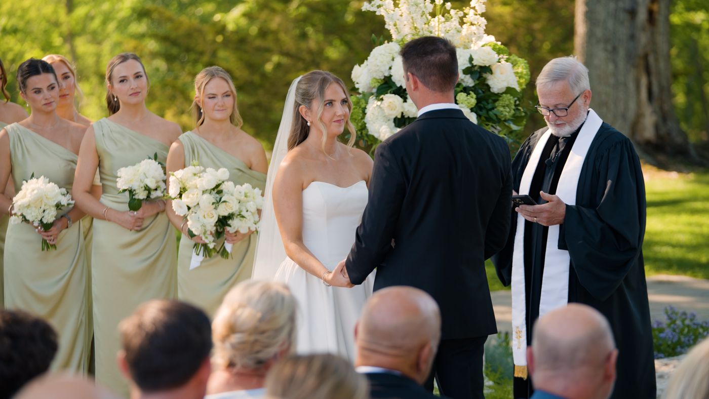 Close angle on the bride during the vows, bridesmaids looking on