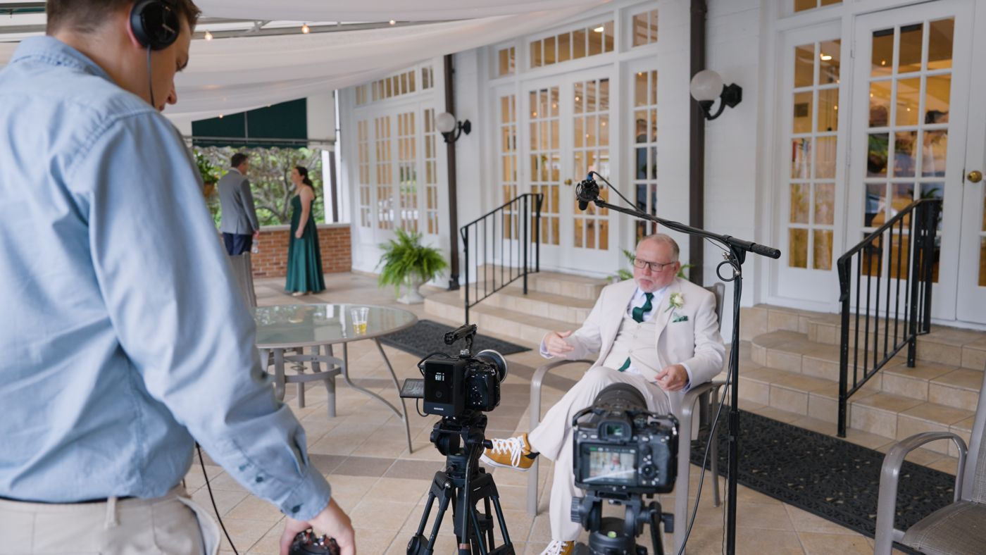 Behind the scenes: two cameras and a boom mic set up for a guest interview on a venue patio